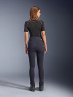 Alpinestars Stella Flex-AST Leggings in nero, pantaloni da moto da donna a vita alta, vista posteriore che mostra la vestibilità skinny e le tasche posteriori, indossati con top nero a maniche corte e stivali da moto, abbigliamento per guida urbana