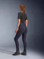 Leggings Alpinestars Stella Flex-Ast da donna, nero, vista posteriore con vestibilità a vita alta e tasche posteriori, indossati con base layer nero a maniche corte con dettagli rossi e scarpe da moto nere, abbigliamento da moto urban contemporaneo