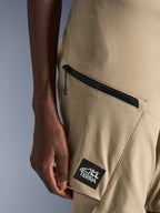 Alpinestars Stella Flex-AST Explorer Pants, pantaloni da moto da donna, sabbia, dettaglio ravvicinato della tasca cargo con cerniera e patch nera con logo ALL TERRA, costruzione in tessuto ripstop resistente per l'adventure touring