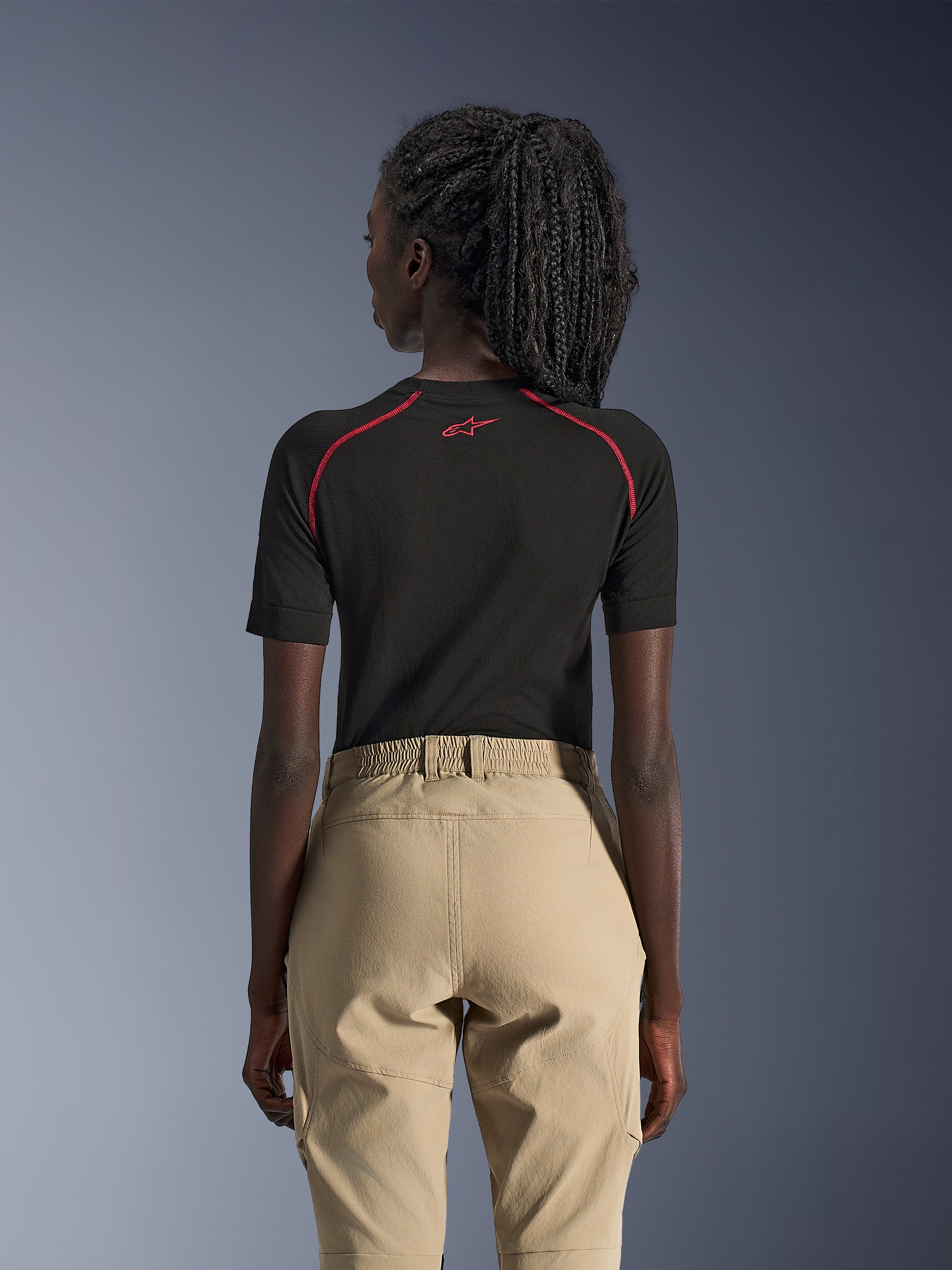 Pantaloni Alpinestars Stella Flex-AST Explorer da donna, color sabbia, pantaloni da moto adventure, vista posteriore, indossati con un base layer nero a maniche corte con accenti rossi, caratterizzati da vita elastica e costruzione in tessuto resistente