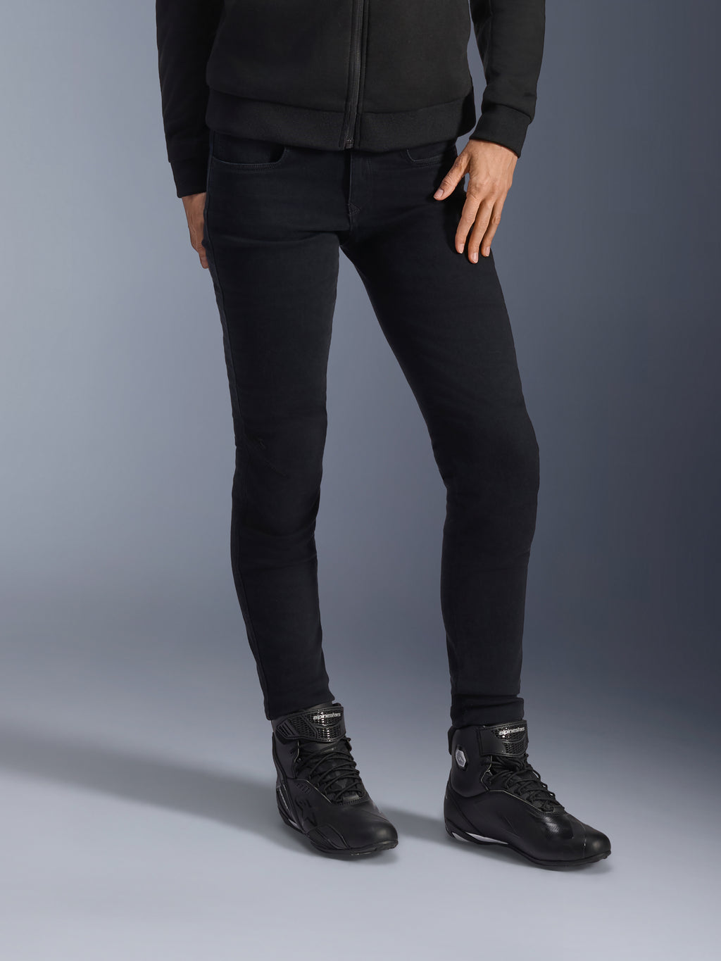 Alpinestars Daisy V3 Women's Riding Denim, Rinse Black, jeans da moto vestibilità slim, abbinati a stivali da moto alti neri e felpa con zip, stile urbano monocromatico elegante