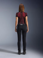 Alpinestars Daisy V3 Women's Riding Denim, Rinse Black, pantaloni da moto slim fit visti da dietro, con design a vita alta e tasche posteriori, abbinati a maglia tecnica rossa e nera e stivali neri, abbigliamento moto urban da donna
