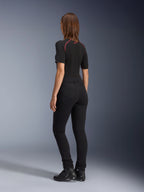 Alpinestars Leggings Banshee Donna, nero, vista posteriore con vestibilità anatomica elasticizzata e tasche posteriori, indossati con maglia nera a maniche corte e stivali da moto, abbigliamento urban elegante da motociclismo per donna