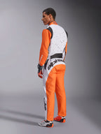 Tuta Alpinestars KMX-9 V3 Graphic 6, tuta da karting, bianco, arancione e nero, vista posteriore con busto bianco e grafiche splatter nere, maniche e pantaloni arancioni, grande logo nero sulla parte bassa della schiena, completa di guanti e calzature da gara coordinati