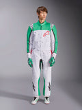 Tuta Alpinestars KMX-9 V3 Graphic 6, bianco, verde e rosso, tuta da karting intera con motivo grafico splatter nero, pannelli verdi su maniche e gambe, logo Alpinestars rosso sul petto, indossata con guanti e scarpe da corsa abbinati