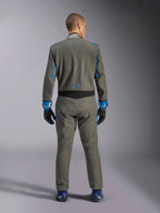 Tuta Alpinestars GP Race V3 FIA, vista posteriore, Blu Antracite con vivaci dettagli blu su braccia e spalle, logo a stella blu sulla parte bassa della schiena, indossata con guanti da corsa abbinati e scarpe blu, tuta professionale per gare automobilistiche
