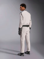 Tuta Alpinestars GP Race V3 FIA, tuta da corsa Silver Anthracite, vista laterale e posteriore, indossata con guanti e stivali da corsa neri, con accenti grigio scuro su vita e spalle, abbigliamento protettivo professionale per automobilismo.