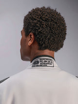 Alpinestars Tuta GP Race V3 FIA, Silver Anthracite, primo piano del colletto posteriore con l'etichetta di certificazione FIA 8856-2018 ricamata, che attesta la conformità di sicurezza per l'abbigliamento da gara automobilistica.