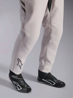 Alpinestars GP Race V3 Suit FIA, tuta da corsa Silver Anthracite, dettaglio della parte inferiore delle gambe e stivaletti da corsa neri, con logo Astars nero sul polpaccio, abbigliamento professionale da motorsport con polsini a coste