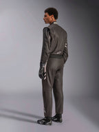Alpinestars GP Race V3 Suit FIA, tuta da corsa automobilistica nera con dettagli argento, indossata da un modello in vista posteriore a tre quarti, abbinata a guanti e stivali da corsa neri coordinati, attrezzatura professionale da motorsport con design a due strati.