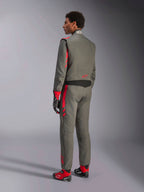 Alpinestars GP Race V3 Suit FIA, tuta da corsa grigio antracite e rosso, vista posteriore del modello che indossa la tuta a due strati, accenti rossi su spalle e gambe, abbinata a guanti e stivali coordinati, equipaggiamento professionale per gare automobilistiche