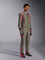 Alpinestars GP Race V3 Suit FIA, tuta da corsa auto antracite e rosso, indossata con guanti e scarpe da corsa abbinati, con spalline e loghi rossi, elegante design tecnico a due strati per il motorsport
