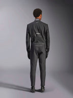 Tuta Alpinestars Hypertech V3, Black Dark Shadow, vista posteriore di una tuta intera professionale da auto racing, con etichetta di certificazione FIA sul colletto e marchi 'Alpinestars' e 'RACING AHEAD' sulla zona lombare, indossata con guanti e stivali da corsa neri coordinati.
