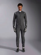 Tuta Alpinestars Hypertech V3, tuta da corsa professionale, nero e Dark Shadow, indossata da un modello con guanti e scarpe da corsa coordinati, vestibilità atletica aderente con accenti argento e loghi, abbigliamento motorsport ad alte prestazioni