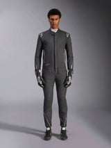 Tuta Alpinestars Hypertech V3, tuta da corsa professionale, nero e Dark Shadow, indossata da un modello con guanti e scarpe da corsa coordinati, vestibilità atletica aderente con accenti argento e loghi, abbigliamento motorsport ad alte prestazioni