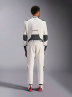 Vista posteriore di un modello che indossa la tuta Alpinestars Hypertech V3 in White Black Silver, che mette in risalto l'ampio pannello elasticizzato lombare nero con i loghi 'alpinestars' e 'RACING AHEAD', inserti neri sui gomiti, l'etichetta di certificazione FIA sul colletto e una vestibilità atletica e aderente progettata per le competizioni professionali.