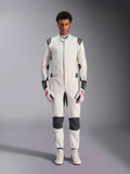 Tuta Alpinestars Hypertech V3, tuta professionale da auto racing, bianco, nero e argento, indossata da un modello con guanti rossi e bianchi e scarpe da racing bianche coordinate, caratterizzata da pannelli neri a contrasto e loghi Alpinestars, design con vestibilità atletica slim fit