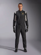Tuta Alpinestars Limited Edition Lamborghini GP Tech V4 FIA, tuta da corsa automobilistica professionale, nera con accenti argento e oro, con logo Automobili Lamborghini Squadra Corse sul petto, indossata con guanti e stivali da corsa coordinati, design atletico ed elegante per competizioni in circuito