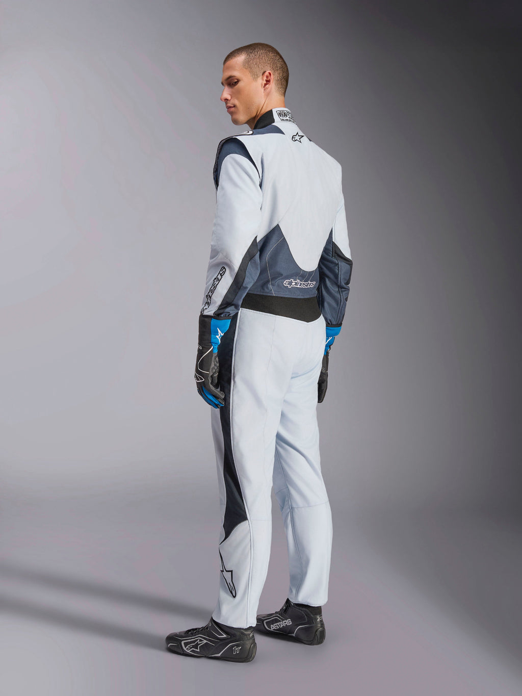 Alpinestars Tuta GP Pro Comp V2 FIA, tuta da corsa auto da uomo, argento e blu, con pannelli elastici posteriori.
