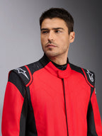 Modello che indossa la tuta auto Alpinestars GP Pro Comp V2 FIA, rosso e nero, con loghi Astars bianchi sulle spalle e dettagli con tecnologia grip in silicone, abbigliamento professionale per motorsport
