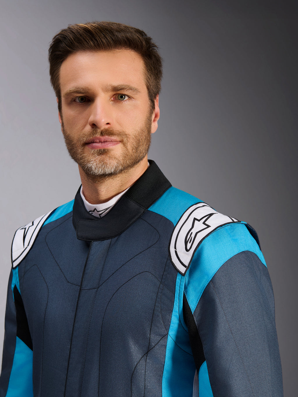 Alpinestars Tuta GP Pro Comp V2 FIA, tuta da corsa auto uomo, grigio asfalto e ciano, primo piano del modello professionale.