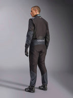 Tuta Alpinestars KMX-5 V3 in Black Dark Shadow, vista posteriore del modello con attrezzatura completa da kart, inclusi guanti e scarpe da corsa coordinati, marchio Alpinestars in vita e accenti dark shadow, attrezzatura professionale da karting.