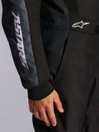 Tuta Alpinestars KMX-5 V3, tuta da kart, nero e Dark Shadow, dettaglio ravvicinato del fianco e del braccio, marchio ASTARS bianco sulla manica, logo bianco in vita, con pannelli in mesh per la ventilazione e polsino in maglia
