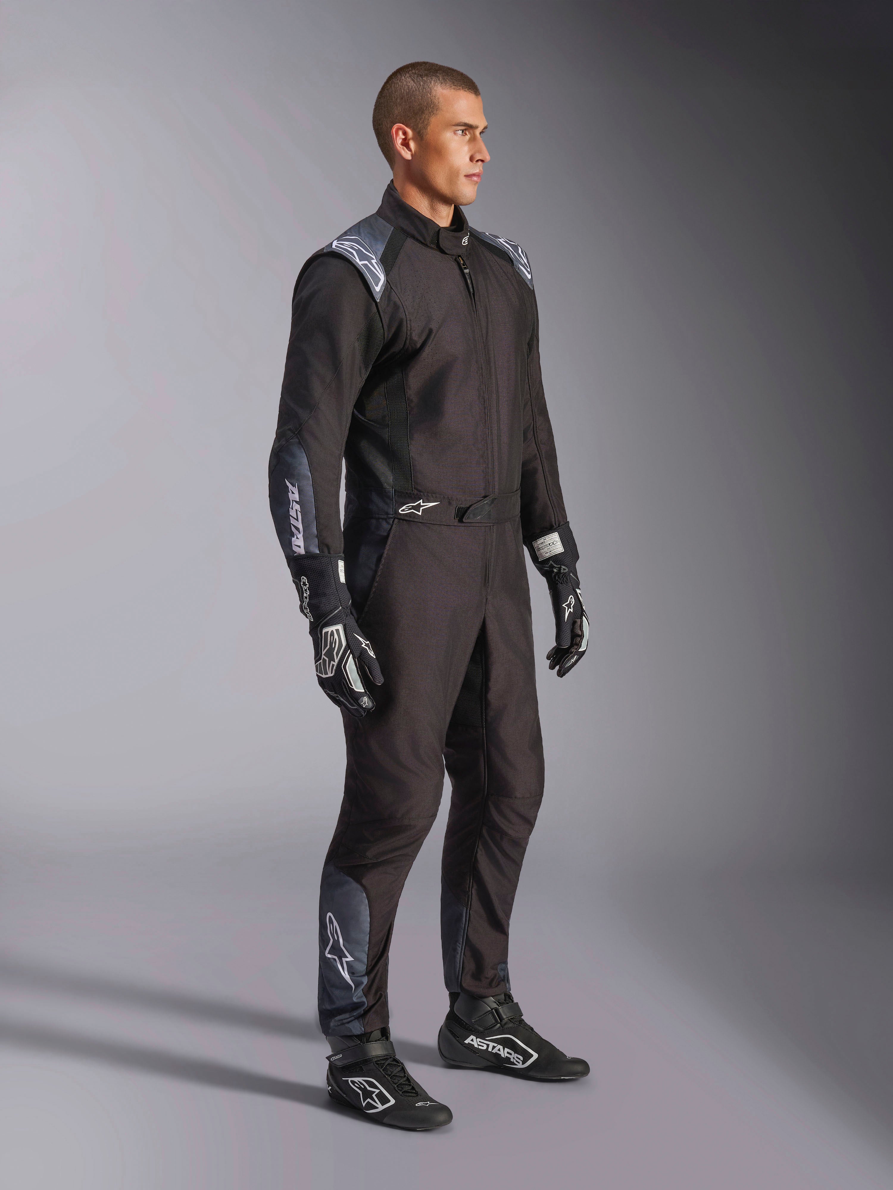Tuta Alpinestars KMX-5 V3, tuta da kart in nero Dark Shadow, indossata con guanti e scarpe da corsa neri coordinati, dotata di traforazioni tagliate al laser e pannelli in mesh tecnico, elegante design a doppio strato con loghi bianchi per il motorsport professionale