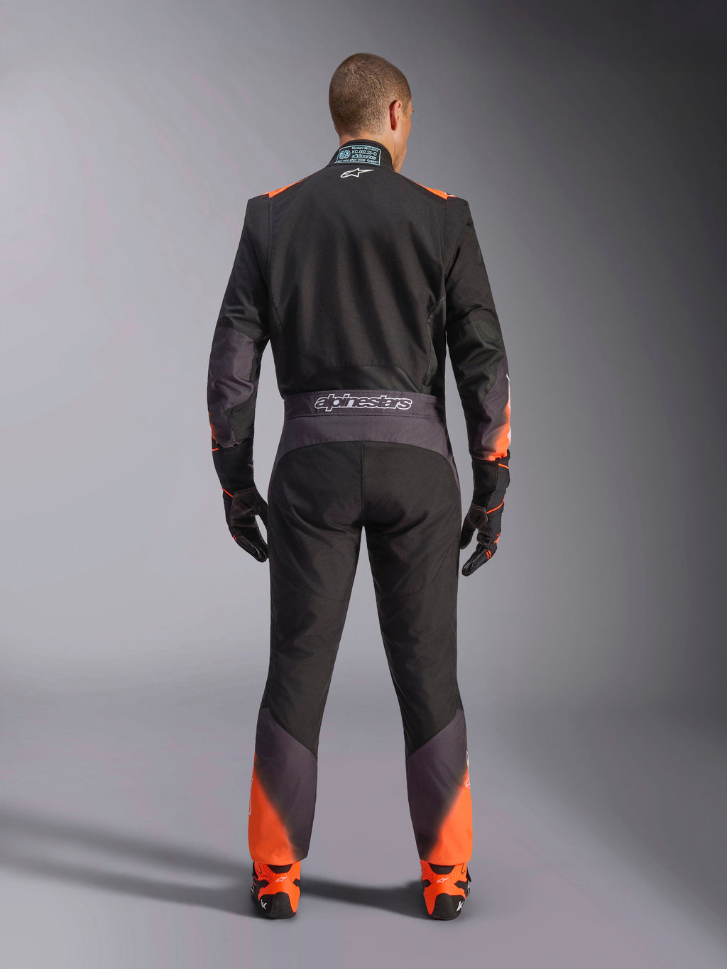 Alpinestars tuta KMX-5 V3, tuta da kart intera uomo, nera e arancione fluo, certificata FIA, vista posteriore con marchio