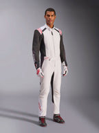 Tuta Alpinestars KMX-5 V3, bianco, nero e rosso brillante, tuta intera da karting indossata con guanti coordinati bianchi e rossi e scarpe da corsa nere, con maniche nere e vivaci accenti rossi, equipaggiamento professionale da motorsport per karting competitivo.