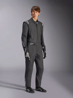 Tuta Alpinestars GP Tech V4, tuta auto intera, nero e bianco, indossata con guanti e calzature da corsa abbinati, caratterizzata da loghi bianchi su spalle e avambracci, design professionale per il motorsport