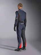 Tuta Alpinestars GP Tech V4, Blue Navy Nero Rosso, vista laterale posteriore di una tuta intera professionale da corsa, con accenti rossi e pannelli neri, indossata con guanti e scarpe da corsa neri, abbigliamento motorsport certificato FIA.