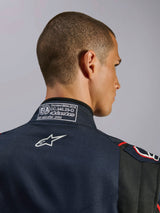 Tuta Alpinestars GP Tech V4 in blu navy, nero e rosso, primo piano del colletto posteriore con l'etichetta di certificazione FIA 8856-2018 e il logo Alpinestars ricamato in bianco, dettaglio di una tuta da corsa automobilistica ad alte prestazioni