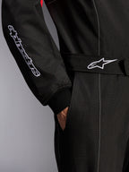 Tuta Alpinestars KMX-9 V3, tuta da karting, nero, rosso e bianco, dettaglio ravvicinato della cintura regolabile con logo a stella e della manica con logo ricamato, con cuciture bianche a contrasto e tasca laterale