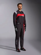Modello che indossa la tuta Alpinestars KMX-9 V3 Graphic 3, tuta da kart, nero e rosso, con spalline bianche e logo rosso sul petto, abbinata a guanti da corsa neri e scarpe con lacci rossi, abbigliamento professionale per motorsport.