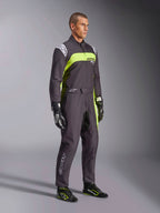 Modello con Tuta Alpinestars KMX-9 V3 Graphic 3 in nero e giallo fluo, abbigliamento professionale da karting con vivaci pannelli giallo neon e dettagli bianchi, accessoriato con guanti e scarpe da corsa coordinati, su sfondo da studio
