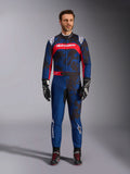 Tuta Alpinestars KMX-9 V3 Graphic 5, tuta da kart in blu navy e rosso, caratterizzata da un motivo grafico astratto in stile camo, indossata da un modello con guanti e scarpe da corsa neri, design atletico con loghi Alpinestars in evidenza su petto e gambe.