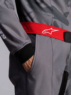 Alpinestars KMX-9 V3 Graphic 5 Suit, tuta da karting, grigio scuro e nero con cintura rossa, primo piano con cintura regolabile rossa con logo bianco, mano nella tasca sulla coscia e polsino in maglia nera su tessuto grigio con motivo grafico