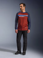 Alpinestars Maxdura Dual Jersey, Rust Brown e Mood Indigo, maglia da moto adventure con busto in rete e maniche blu navy, indossata da un modello con pantaloni da guida neri e stivali neri, abbigliamento tecnico dual-sport per la guida off-road