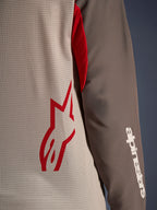 Alpinestars Maxdura Dual Jersey, Aluminum Walnut, vista ravvicinata del busto in mesh ventilato con logo a stella rosso e manica marrone resistente all'abrasione con scritta Alpinestars bianca, abbigliamento tecnico da moto adventure e dual-sport