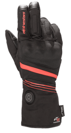 Guanti Alpinestars HT-5 Heat Tech Drystar®, guanti da moto riscaldati, neri con dettagli rossi, dotati di pulsante di accensione circolare sul polsino, strisce rosse su mano e polso, marchio Alpinestars sul dito, progettati per la protezione impermeabile in climi freddi