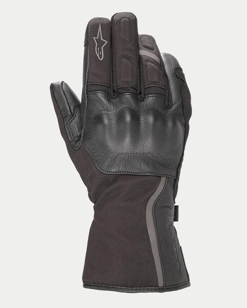 Guanti Alpinestars Stella Tourer W-7 Drystar® da donna, nero, guanto da moto invernale a polsino lungo con costruzione in pelle e softshell, protezione rigida delle nocche ricoperta in pelle, dettagli argento riflettenti e logo Alpinestars sul dito.