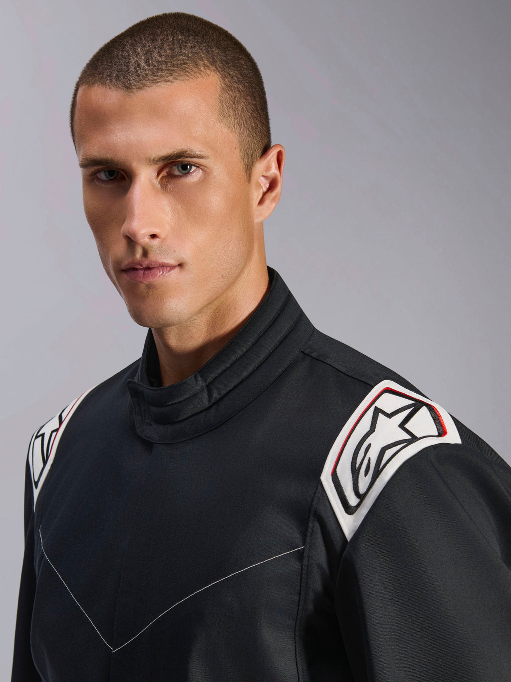 Tuta Alpinestars Kart Indoor V2, nero, vista ravvicinata delle spalle e del colletto, spalline bianche con logo Astars nero, design ergonomico del colletto, resistente costruzione in twill di policotone per il karting indoor
