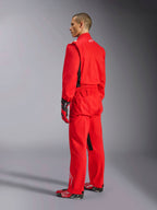Alpinestars Kart Indoor V2 Suit, tuta da kart rossa, vista posteriore di tre quarti su un modello, indossata con guanti rossi coordinati e scarpe da corsa, costruzione in twill di policotone a strato singolo, equipaggiamento professionale da motorsport per il karting indoor.