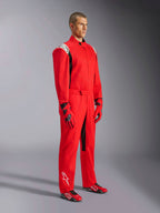 Alpinestars Kart Indoor V2 Suit, tuta da kart rossa, indossata da un modello con guanti e scarpe coordinati rossi e neri, loghi bianchi sulle spalle e sulla parte inferiore della gamba, dettagli neri, progettata per il karting ricreativo e le piste indoor
