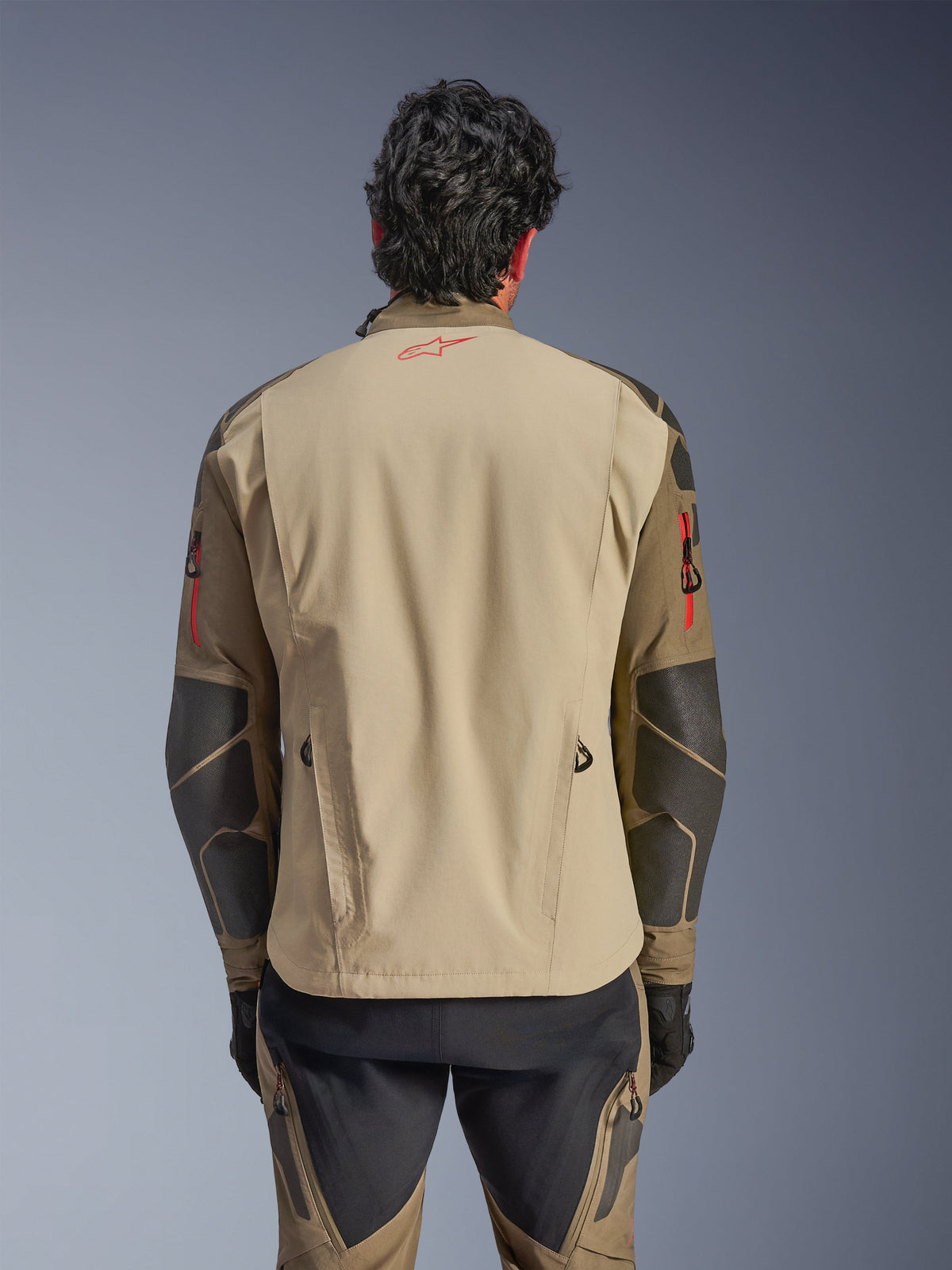 Giacca Alpinestars Nazca 3L GORE-TEX PRO, vista posteriore, colore Walnut Rock Brown, giacca da moto adventure con logo Astars rosso sul collo e dettagli delle zip rossi sulle braccia, dotata di rinforzi in Superfabric sui gomiti.