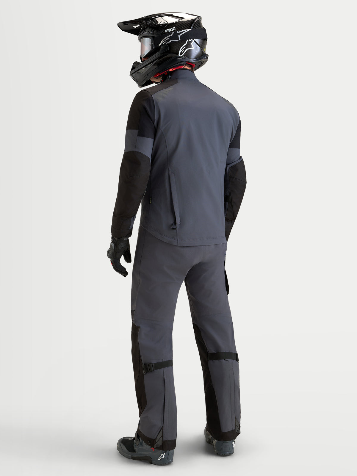 Alpinestars Arenis Gore-Tex® Gear Set, completo da moto adventure touring da uomo in grigio e nero, vista posteriore di un modello che indossa abbigliamento impermeabile e casco