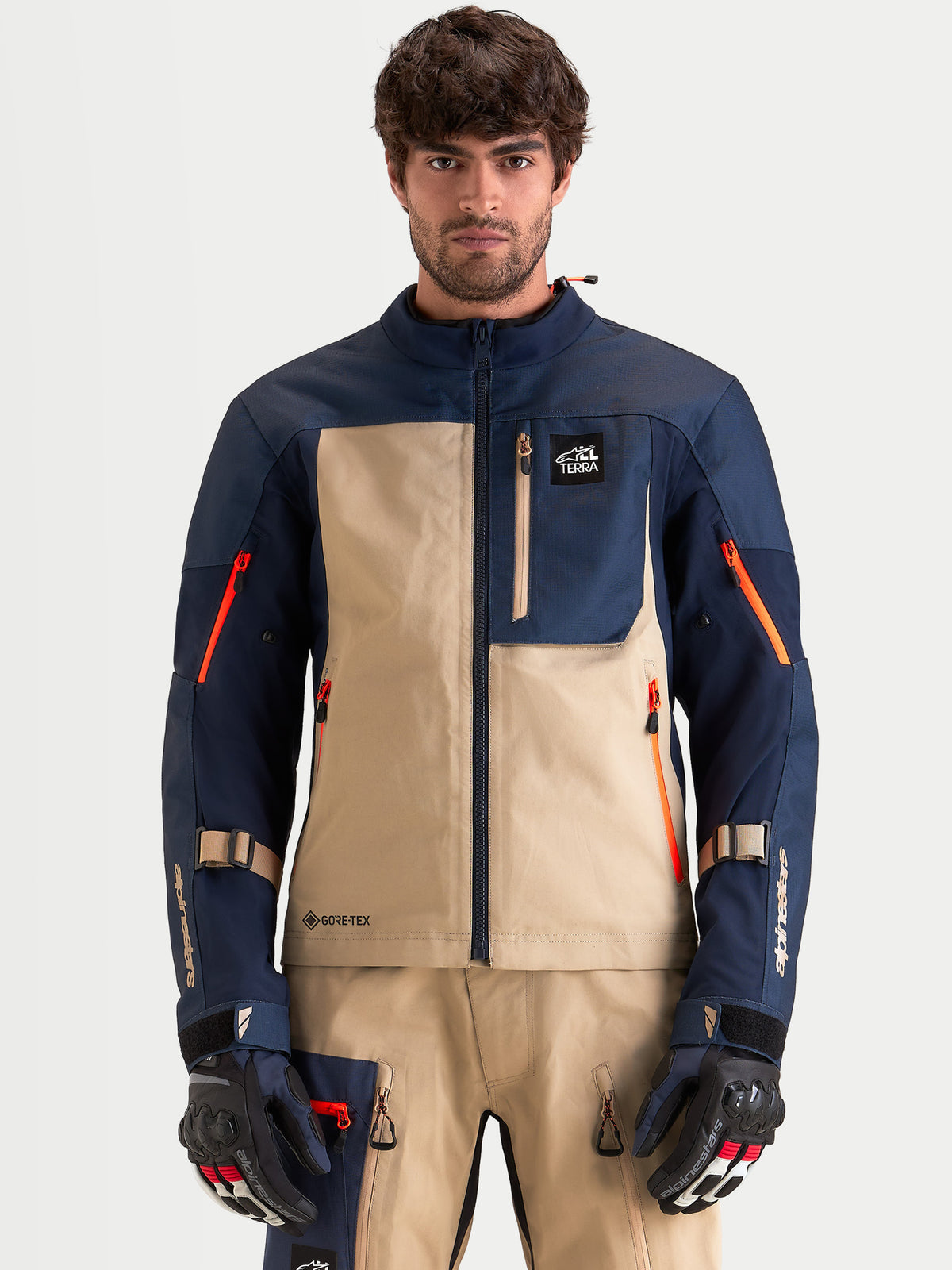 Alpinestars Arenis Gore-Tex Giacca, giacca da moto adventure da uomo in blu navy e alluminio, vista frontale su un modello che indossa guanti e attrezzatura abbinati, con struttura in tessuto impermeabile