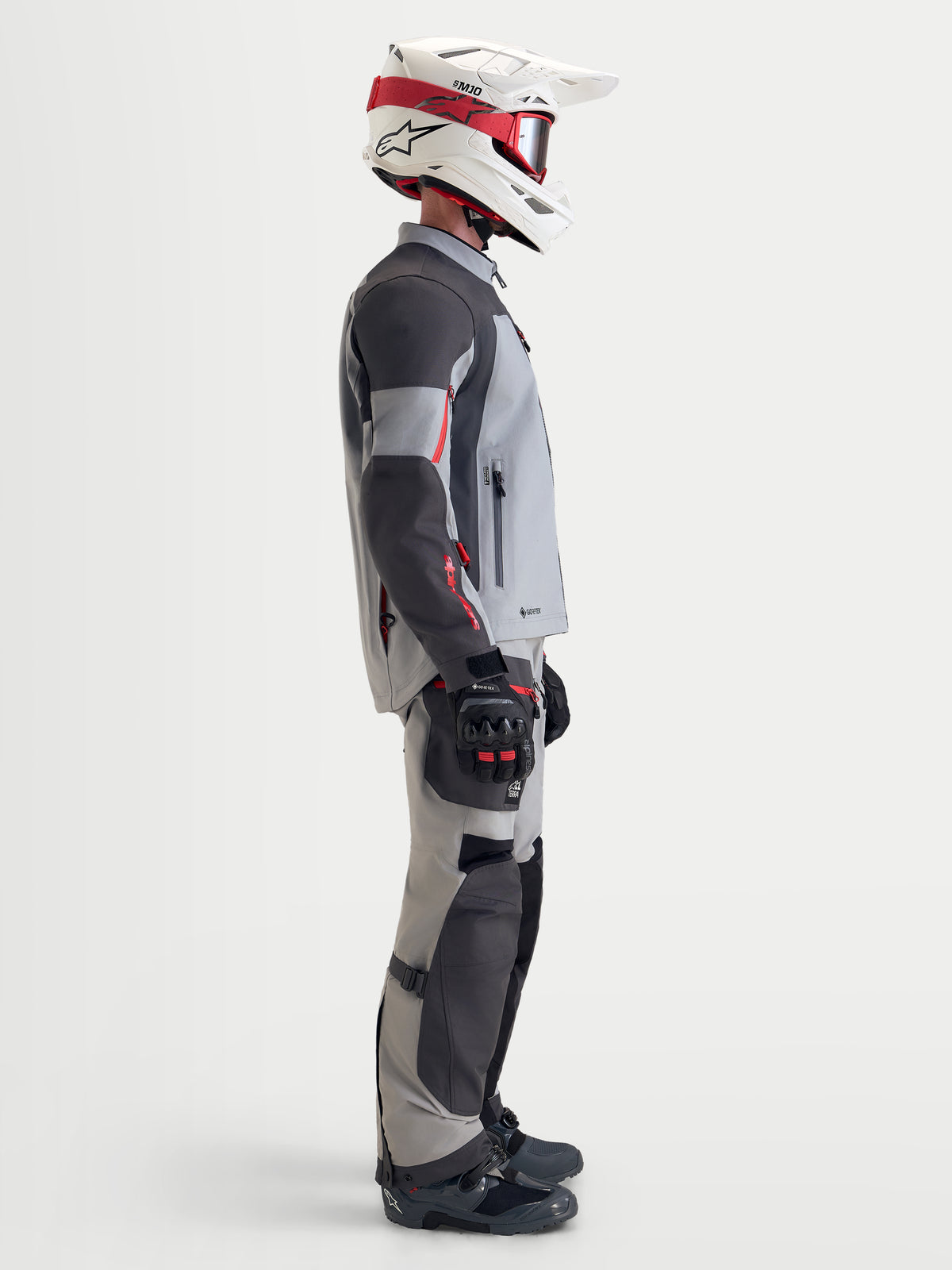 Alpinestars Arenis Gore-Tex Gear Set, completo da moto adventure touring da uomo in grigio e nero, vista di profilo laterale di un modello che indossa abbigliamento coordinato e casco
