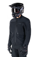 Giacca Alpinestars St-7 Prime GORE-TEX, giacca da moto nera, indossata da un pilota con casco e occhiali neri, dotata di ampie tasche cargo sul petto e guscio impermeabile laminato, abbigliamento premium per adventure touring e commuting
